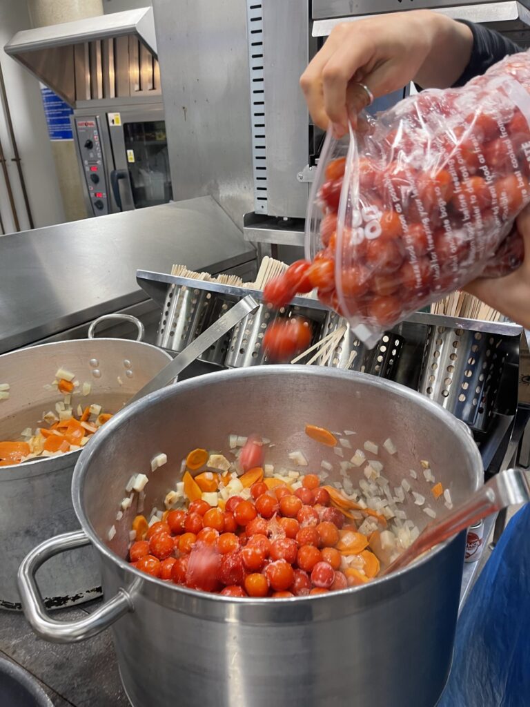 Charity volunteers cooking fresh produce to prepare meals for local communities