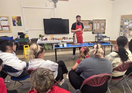 FareShare Cymru's Culinary Lead doing a cooking demonstration to parents and schoolchildren